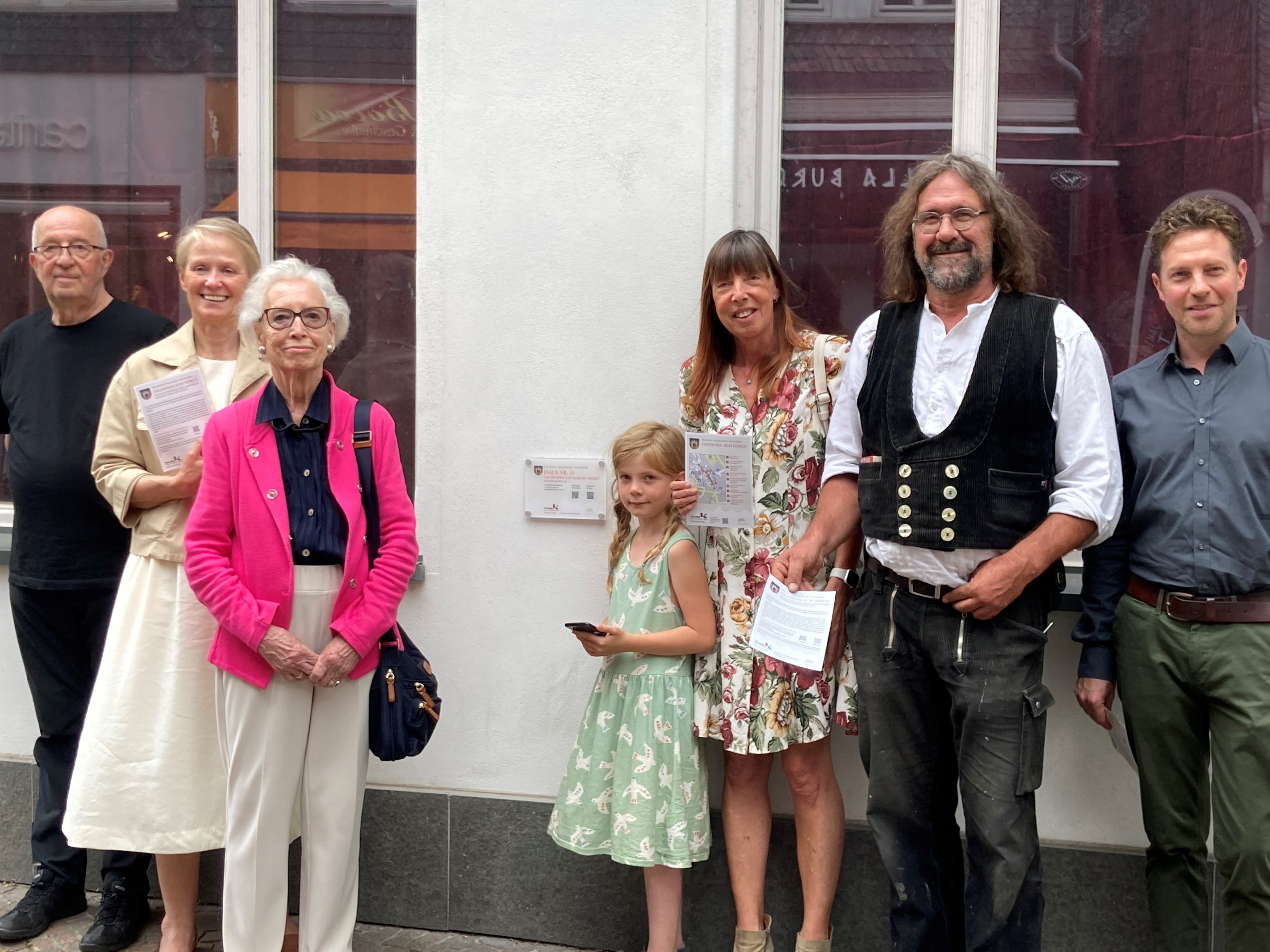 Die Verantwortlichen der Projektgruppe vor einer der Hinweisschilder zum Erlebnis-Rundgang auf dem Kleinen Markt.