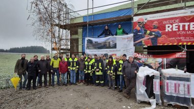 Bild zeigt beteiligte Akteure vor dem Rohbau während des Richtfests