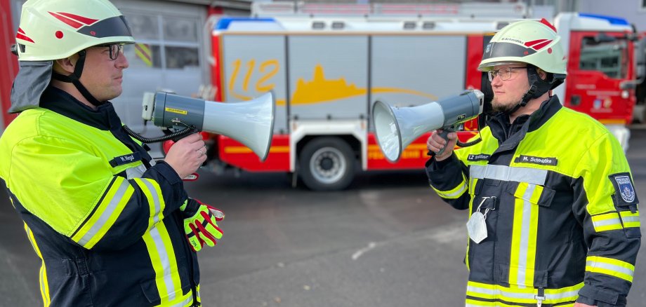 Markus Negd und Michael Schmidtke mit zwei der neuen Megafone vor der Feuerwache in Montabaur.