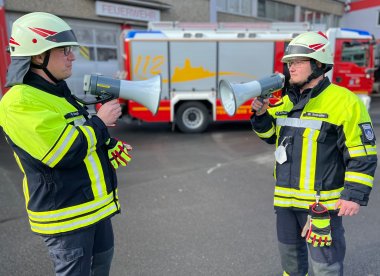 Markus Negd und Michael Schmidtke mit zwei der neuen Megafone vor der Feuerwache in Montabaur.