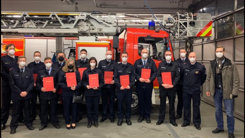 Bild zeigt Feuerwehrkameradinnen und Kameraden bei der Beförderung