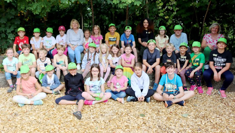 Die Teilnehmer und Betreuer der ersten Ferienbetreuungswoche strahlen beim gemeinsamen Gruppenfoto in die Kamera.