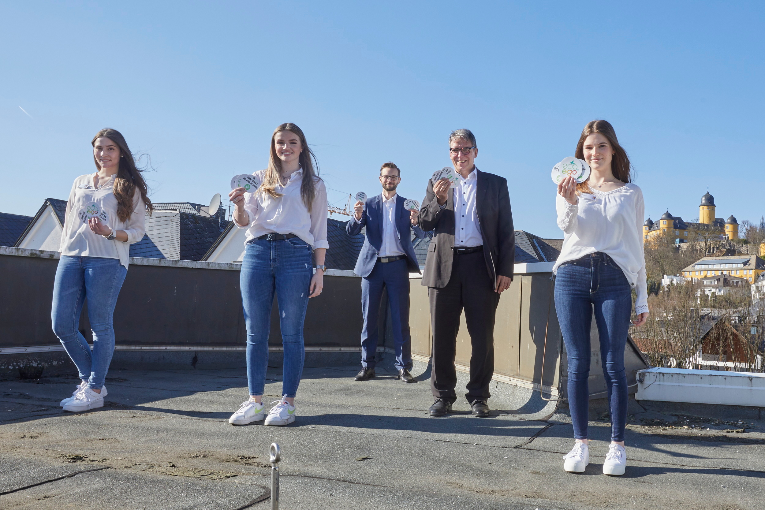 Die drei Azubis präsentieren gemeinsam mit Bürgermeister Richter-Hopprich und dem Ersten Beigeordneten Stein die entwickelten Energiespar-Aufkleber.