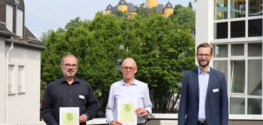 Bürgermeister Ulrich Richter-Hopprich überreicht Heiko Hickmann und Johannes Noll die Gewinnerurkunden der Klima-Coach-Aktion.