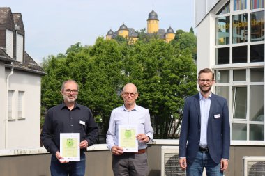 Bürgermeister Ulrich Richter-Hopprich überreicht Heiko Hickmann und Johannes Noll die Gewinnerurkunden der Klima-Coach-Aktion.