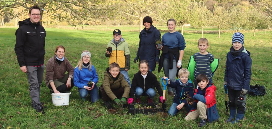 Ortsbürgermeister Sebastian Stendebach mit Linda Müller und der Gruppe von Kindern, die gemeinsam Setzlinge gepflanzt haben.