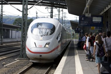 Fahrgäste warten am Bahnstein auf den einfahrenden ICE.