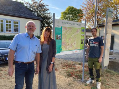 Ralf Heibel, Karin Maas und Stefan Eschenauer stehen vor der neuen Portaltafel.