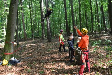 Die Kinder beim Klettern. Ein Erwachsener sichert ab.