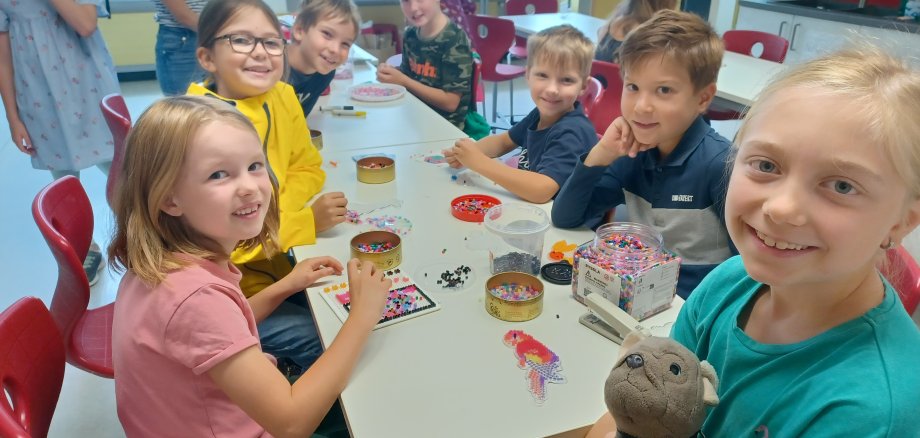 Kinder der Ferienbetreuung beim Spielen und Basteln.