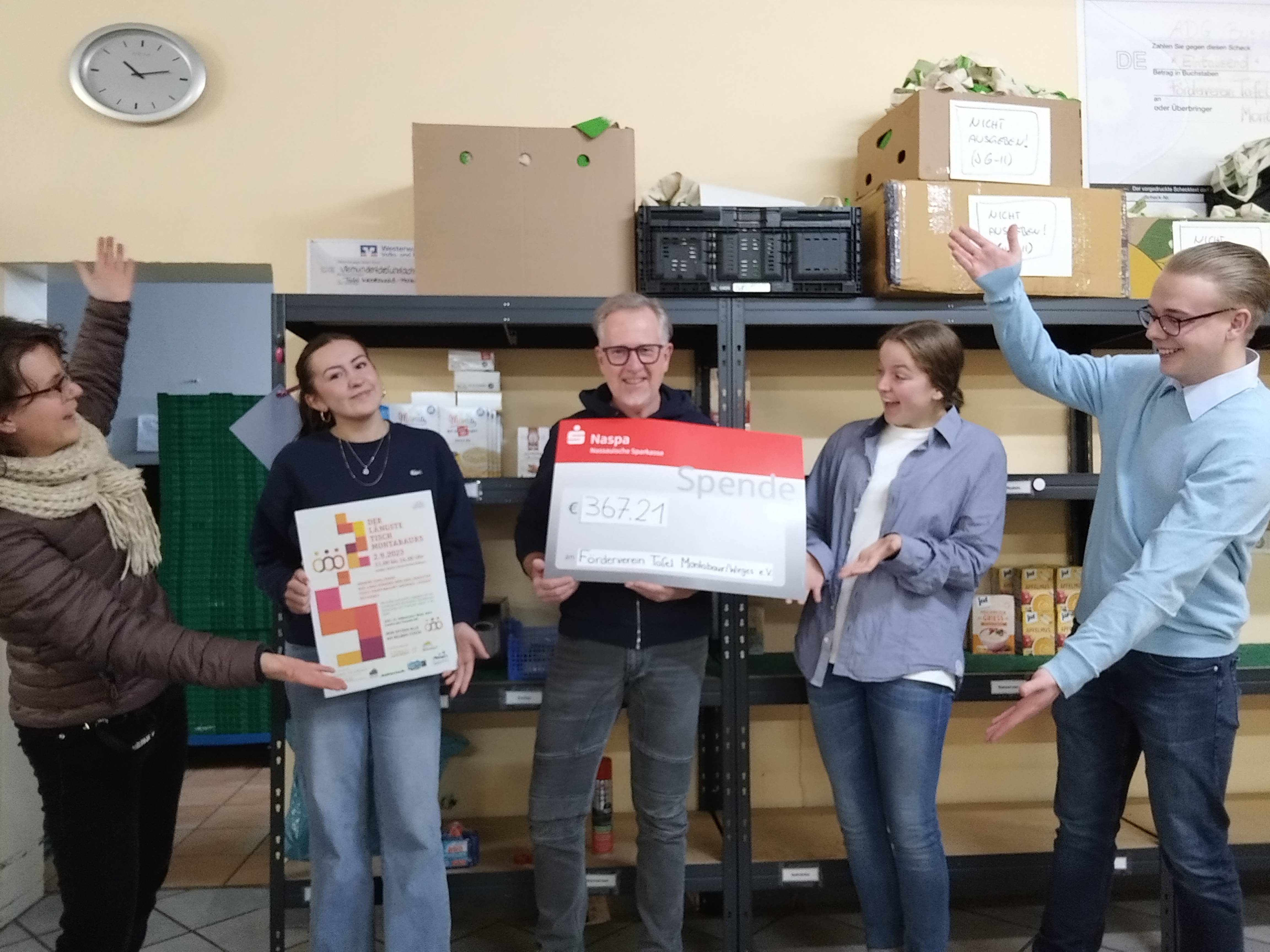 Das Orgateam übergibt den Spendenscheck an Alexander Schnupp von der Tafel.