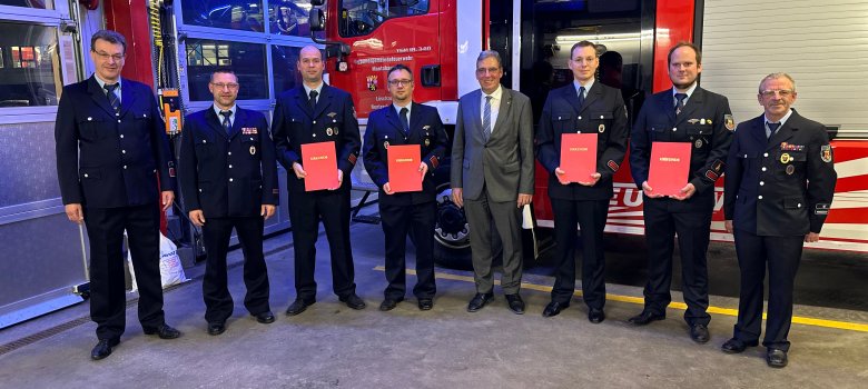 Der Erste Beigeordnete Andree Stein mit den Verantwortlichen der Freiwilligen Feuerwehr Nentershausen vor einem Löschfahrzeug.