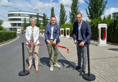 Stadtbürgermeisterin Gabi Wieland, Stephan Schäfer, CEO von Outlet Centres International, und Verbandsgemeindebürgermeister Ulrich Richter-Hopprich schneiden das rote Band durch und eröffnen die neue Tesla-Ladestation.