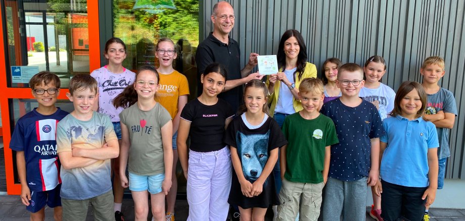 Die Kinder und Konrektorin Anne Thomi freuen sich übe rdie Plakette, die ihnen überreicht wird.