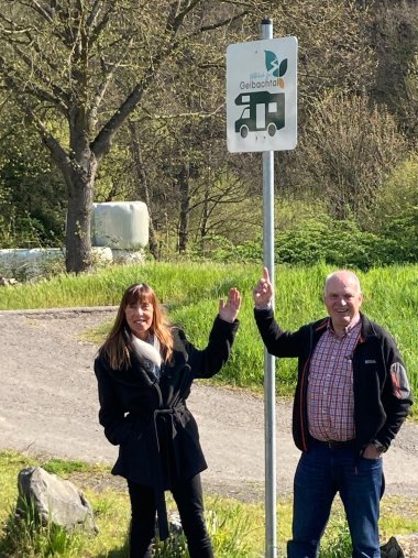 Ettersdorfs Ortsvorsteher Karl Ortseifen und Projektleiterin Karin Maas vor dem Hinweisschild für den Wohnmobil-Stellplatz.