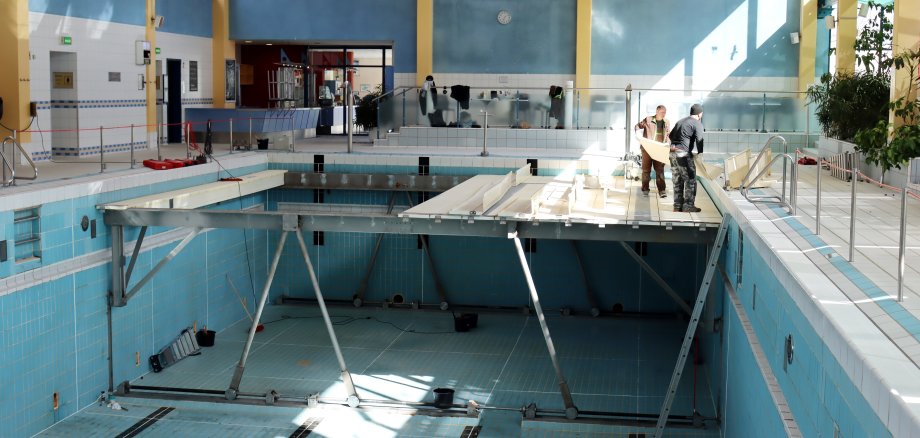 Bild zeigt leeres Schwimmbecken in dem Bauarbeiten stattfinden