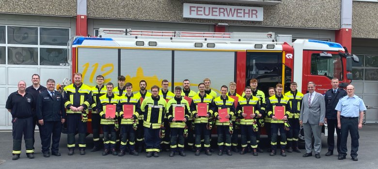 Die erfolgreichen Feuerwehrleute präsentieren stolz ihre Urkunden. 