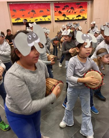 Die Kinder verkleidet als Elefanten, Giraffen, Affen und Gazellen mit ihren Trommeln.