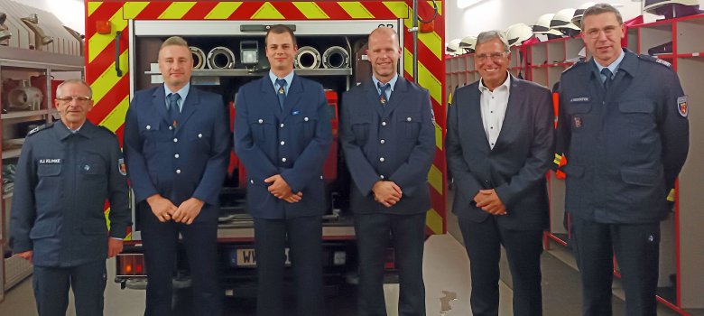Die Verantwortlichen der Feuerwehr Girod vor einem Feuerwehrfahrzeug.