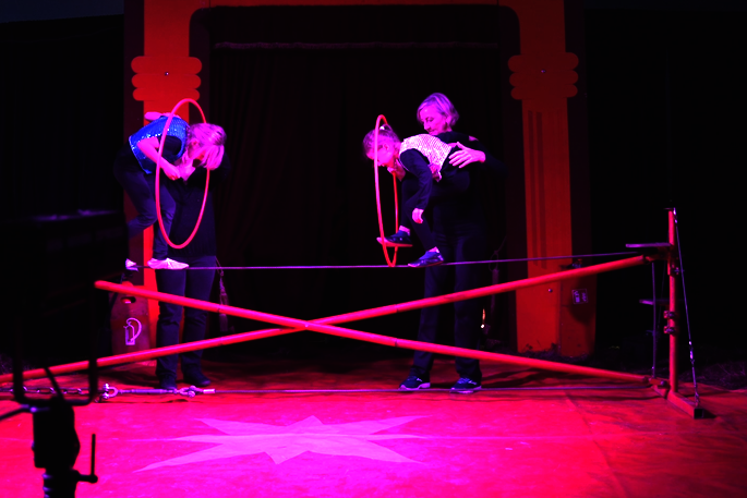 Zwei Schüler bei ihrem Auftritt auf dem Drahtseil, gehen durch Reifen.