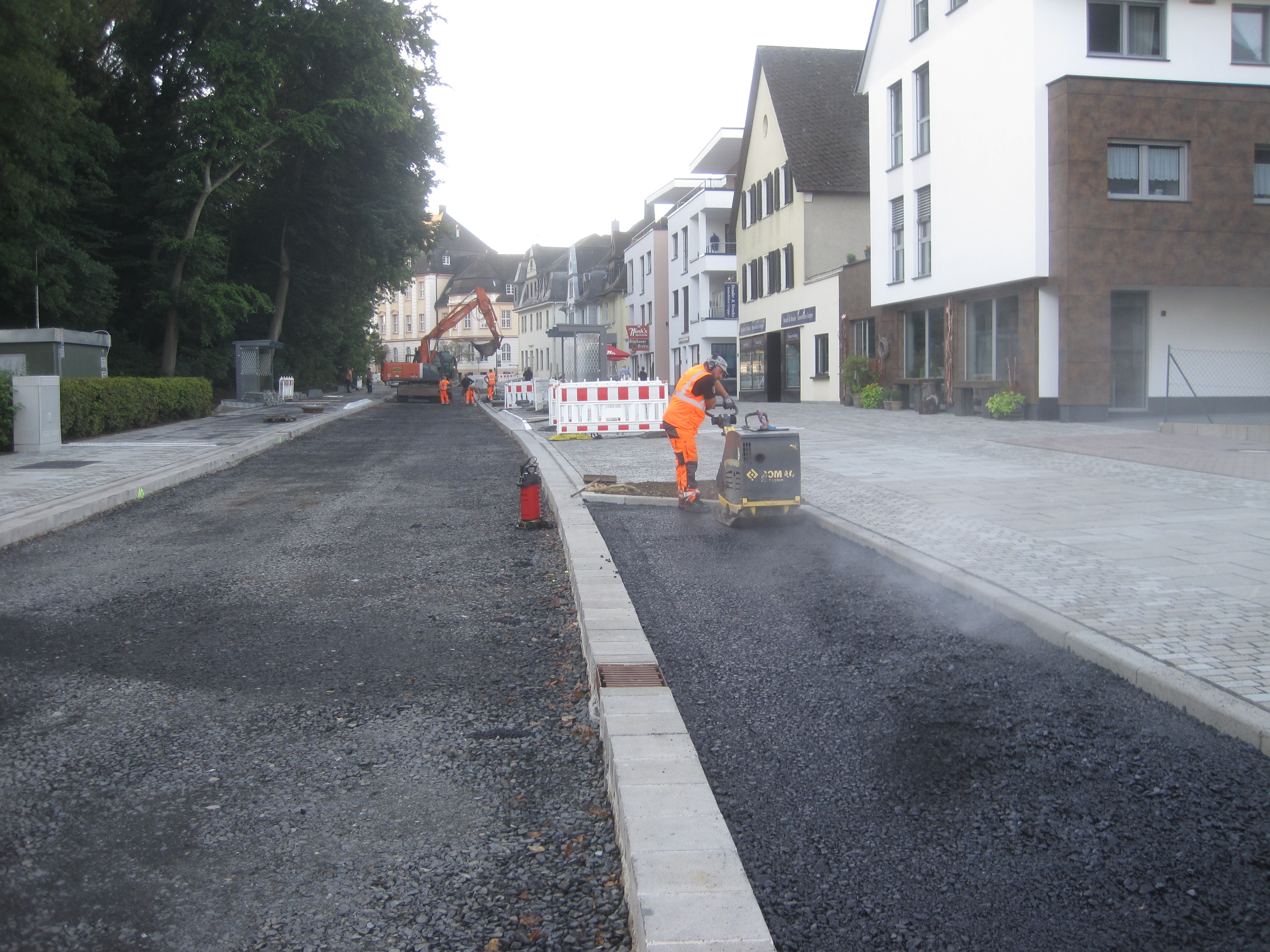 Bauarbeiter beim asphaltieren der Bahnhofstraße.