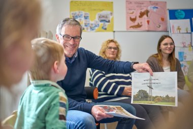 Norbert Rausch zeigt den Kindern der Kita Löwenzahn wie der Strom vom Kraftwerk in die Steckdose kommt.