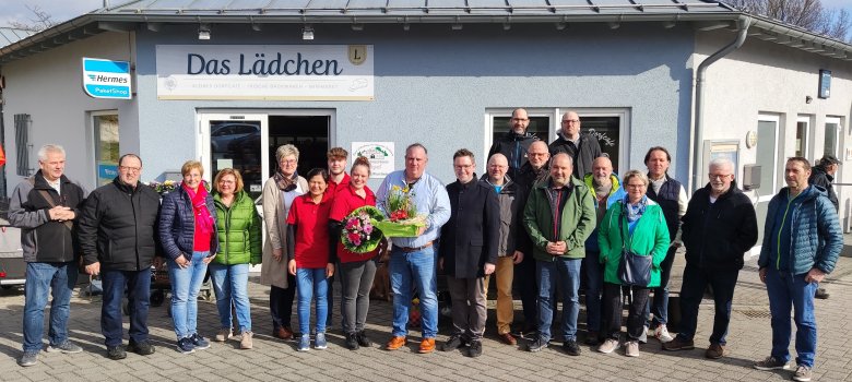 Carlo Rossbach, Ortsbürgermeister Sebastian Stendebach sowie Mitglieder des Ortsgemeinderates und Vertreter der Vereine vor dem Dorfladen „Das Lädchen“.