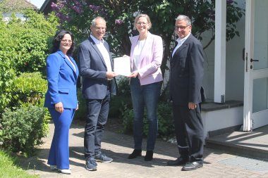 Innenstaatssekretärin Simone Schneider übergibt einen Förderbescheid an Ortsbürgermeister Hans Ulrich Weidenfeller. Mit dabei die 1. Ortsbeigeordnete Yvonne Schlosser und Andree Stein, der Erste Beigeordnete der Verbandsgemeinde Montabaur.