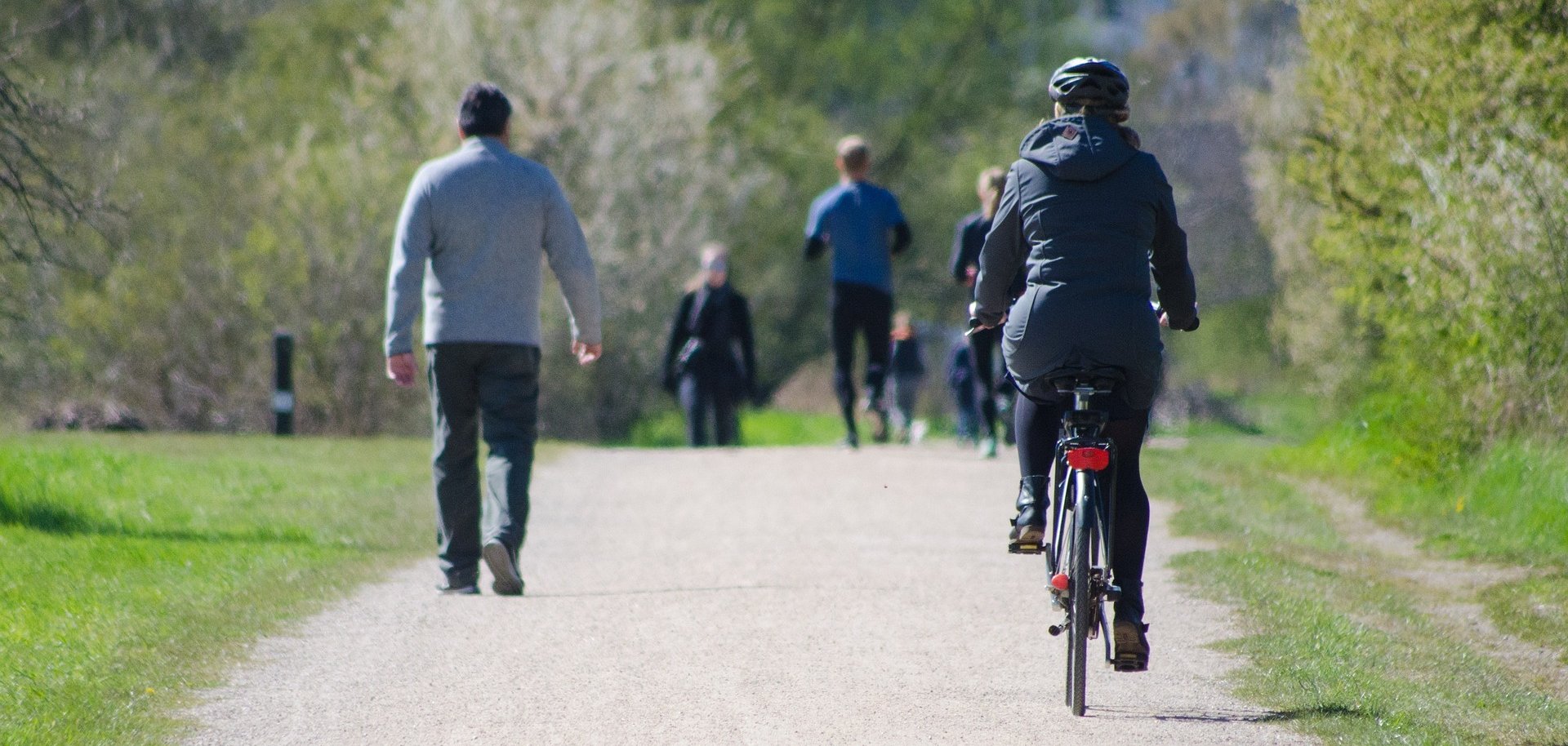 Fahrradfahrer und Fußgänger in einem Park.