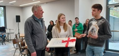 Die Schülersprecher überreichen dem Hausmeister ein selbstgemachtes Geschenk der Schülerschaft.