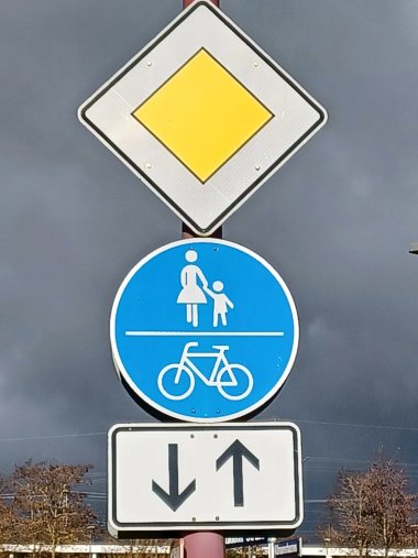 Ein Vorfahrtsschild und ein Schild zur Markierung eines Fuß- und Radweges sind abgebildet.