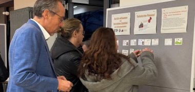 Direkt nach dem Ankommen pinnen die Teilnehmer ihre Visitenkarten an eine Pinnwand.