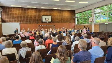 Schüler die ein Gedicht aufführen während das Publikum zuschaut