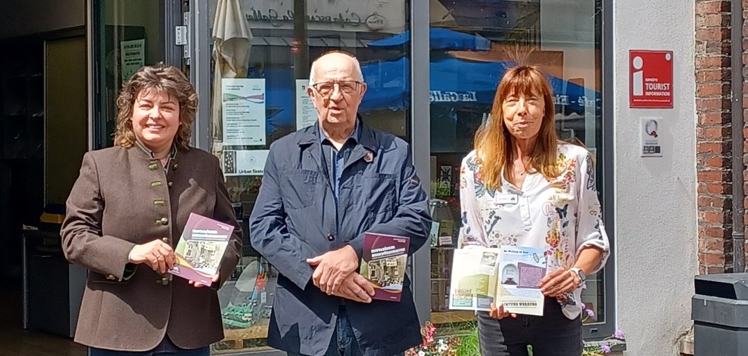 Drei Personen stehen nebeneinander und halten das neue Booklet „Montabäurer Merkwürdigkeiten“ in den Händen. Der Autor und Geschichtensammler Bernd Schrupp (Mitte) wird dabei von Stadtbürgermeisterin Melanie Leicher (links) und Karin Maas, der Leiterin der Tourist-Info, unterstützt.