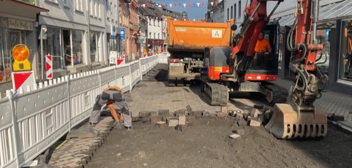 Bild zeigt Bagger auf einer Straße ohne Pflaster