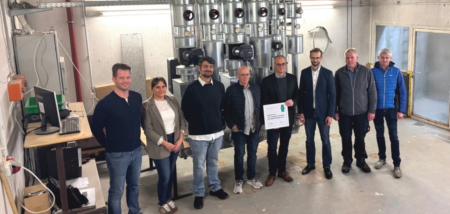 Bild zeigt Beteiligte vor der Heizungsanlage