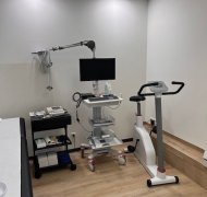 Untersuchungszimmer mit Ergometer, EKG-Monitor, Liege und medizinischen Geräten für die Belastungsdiagnostik.