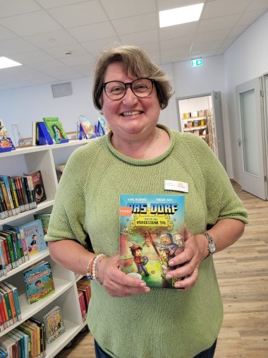 Mitarbeiterin Susanne Walter-Hahn zeigt den neuen Band der Mine-Craft Reihe, die bei Kindern zwischen 8 und 12 Jahren beliebt ist.