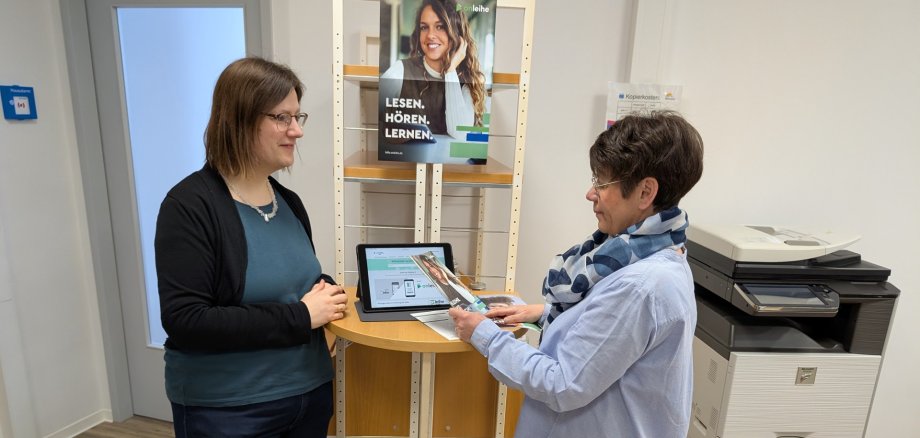 Das Team der Stadtbibliothek Montabaur – hier Carina Senko (l.) und Diane Müller Lopez - berät die Leserinnen und Leser gerne, wie der digitale Umzug zur neue Onleihe funktioniert.