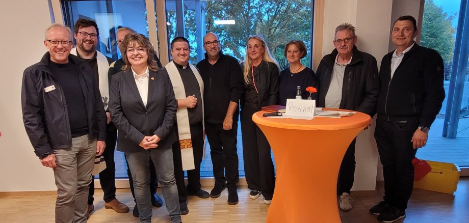 Stadtbürgermeisterin Melanie Leicher, Kita-Leiterin Andrea Fuß und weitere Gäste stehen für ein Gruppenfoto in der Kita zusammen.