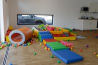 Das Bild zeigt buntes Spielmaterial auf dem Boden
