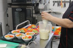 Das Bild zeigt die Zubereitung von  Kindergartenverpflegung