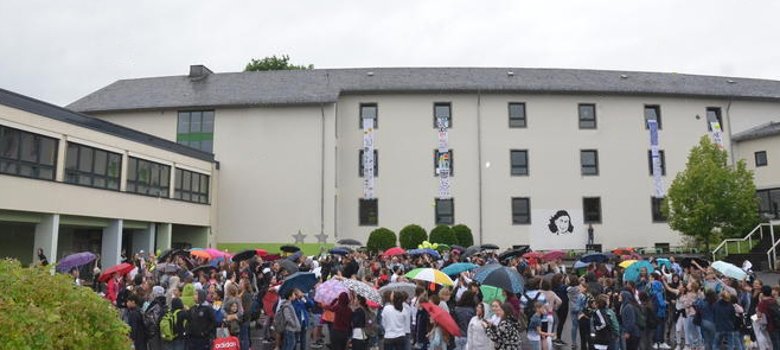 Das Bild zeigt die Außenansicht der Anne-Frank-Realschule Montabaur mit Schülern
