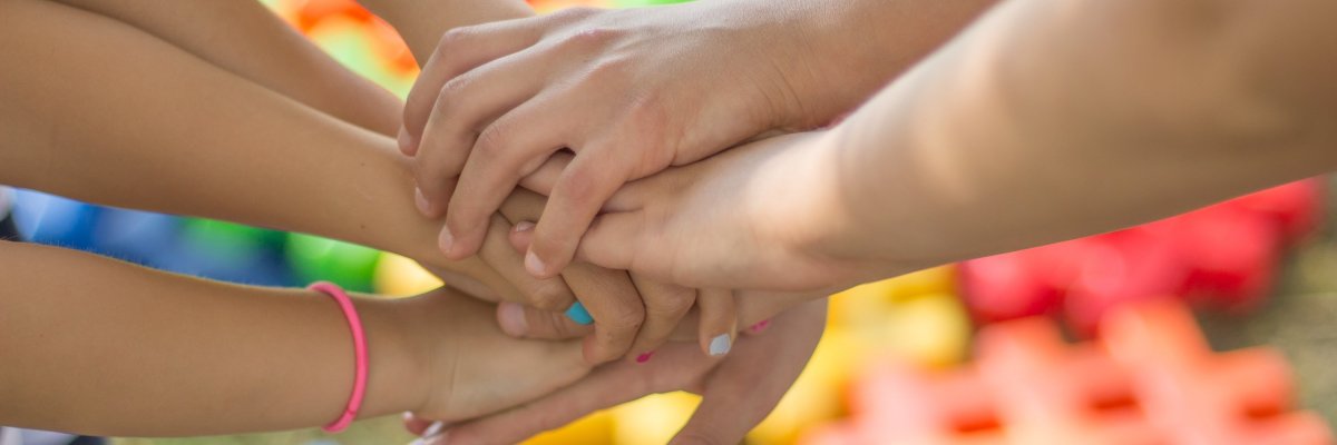 Bild zeigt Kinderhände die übereinander liegen