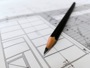 Ein Stift liegt auf einem Bauplan.